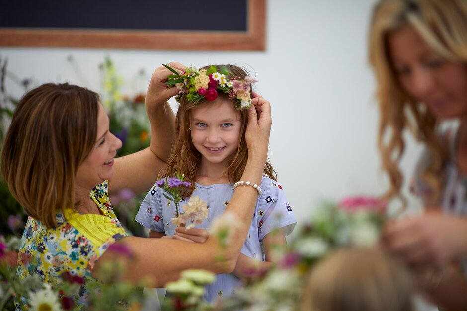 A mother and child in a flower crown workshop A mother and child in a flower crown workshop